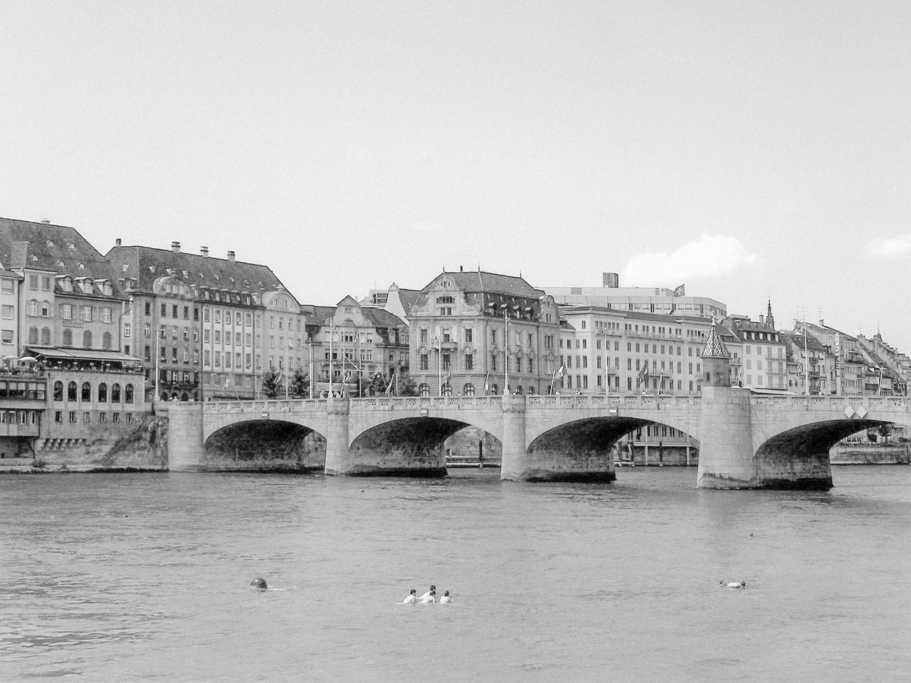 a bridge spanning over a river with several people