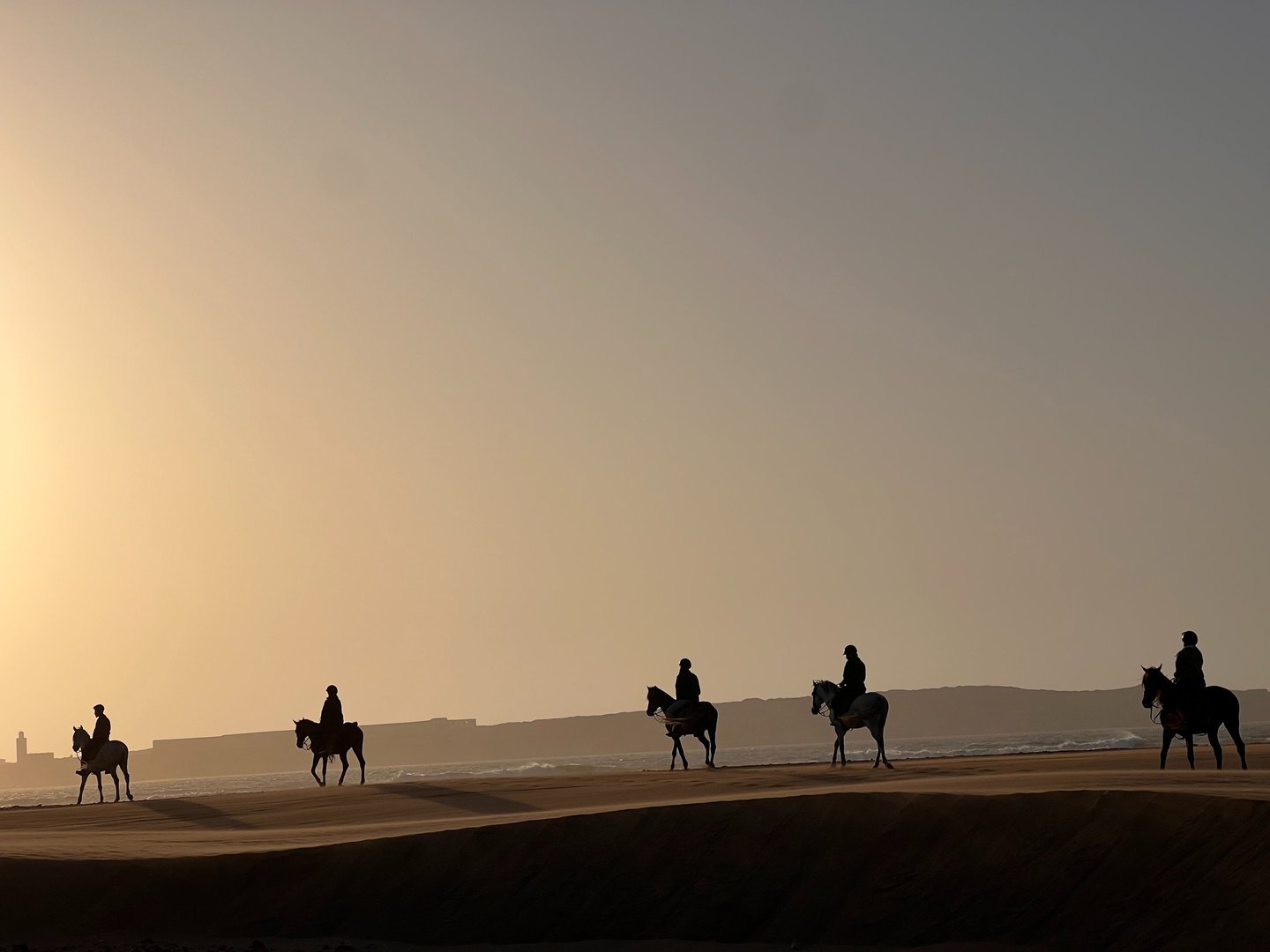 cavaliers dans les dunes au coucher de soleil