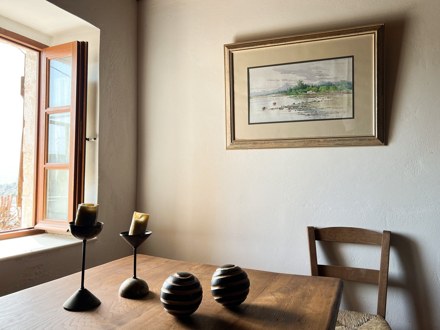 a table with three candles and a picture of a window