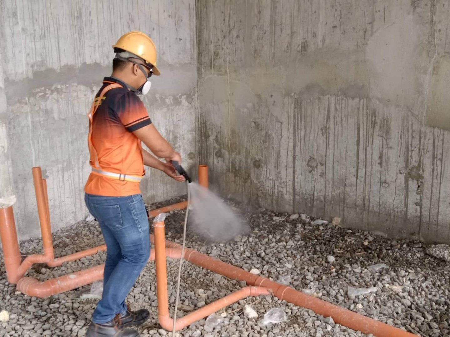 Siquijor pest control technician performing soil poisoning treatment for termites, applying chemical