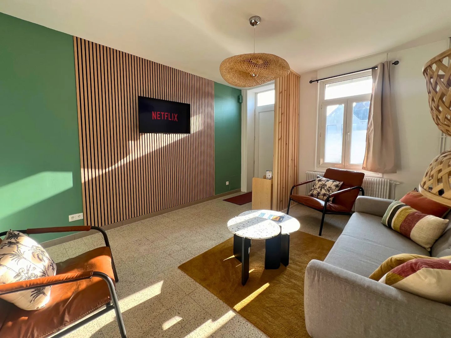 Salon moderne avec TV connectée et canapé, hébergement professionnel tout confort