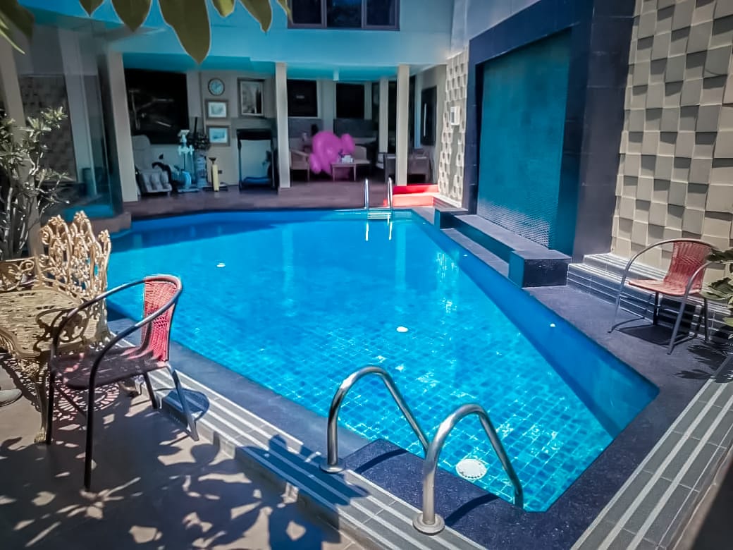 Kolam renang di belakang rumah dengan keramik berwarna biru yang sangat menyejukan.