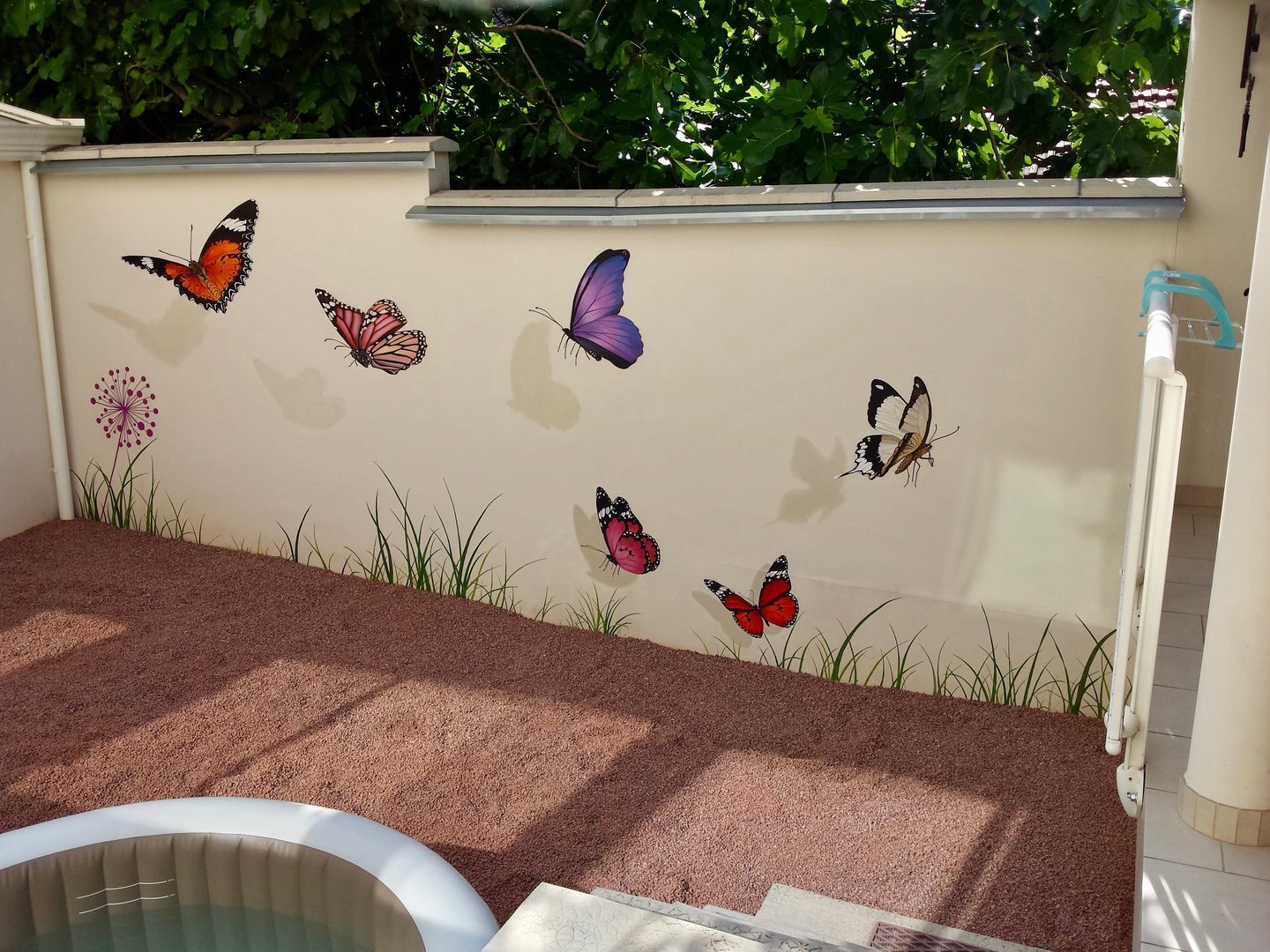 Fresque aux papillons peinte sur un mur mitoyen, de quoi embellir et animer une cour intérieure avec un peu de poésie.