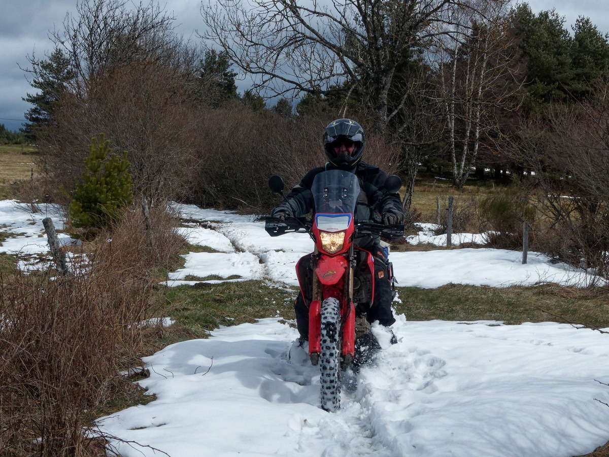 a man riding a motorcycle through the snow