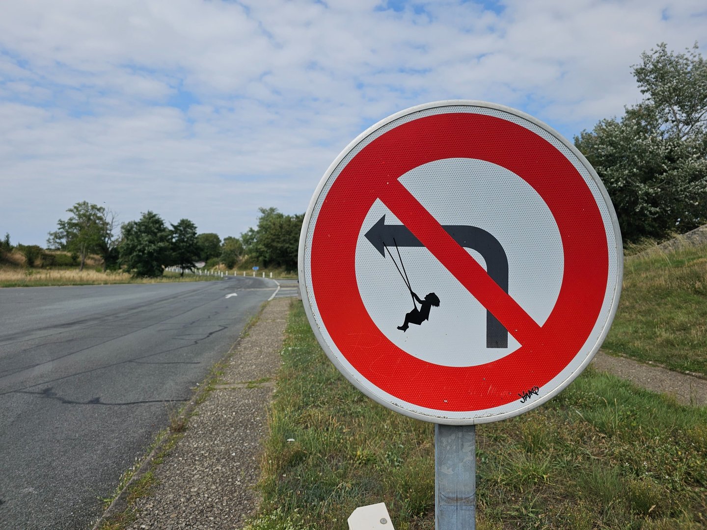Street art sur panneau de signalisation représentant un fille sur une balançoire