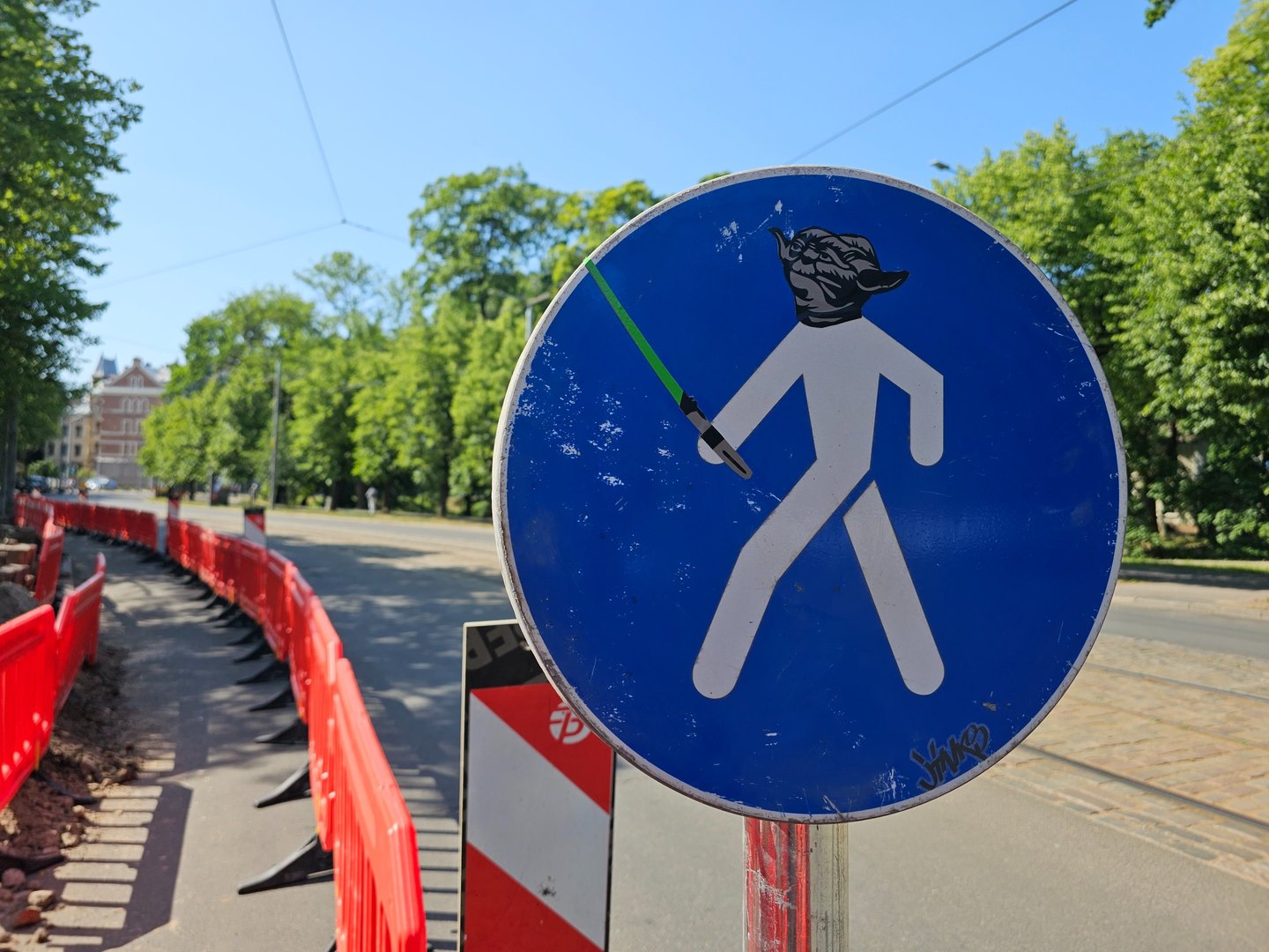 a street sign with a star wars lightsabed sticker on it
