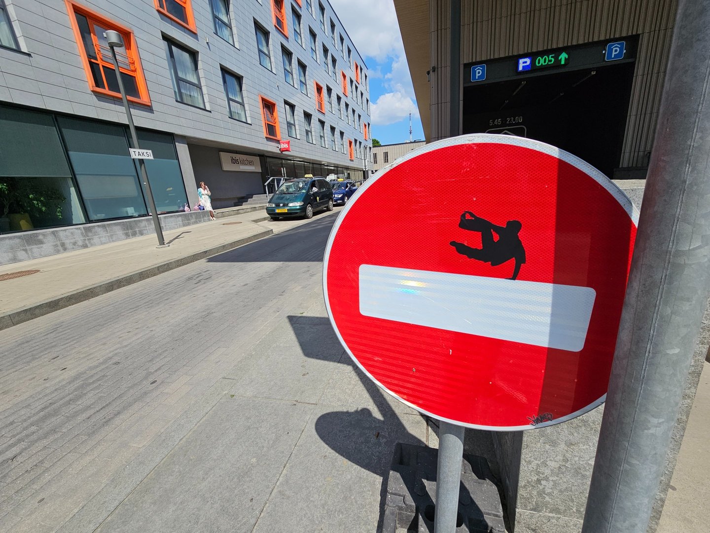 a red and white sign with a picture of a man on a skateboard