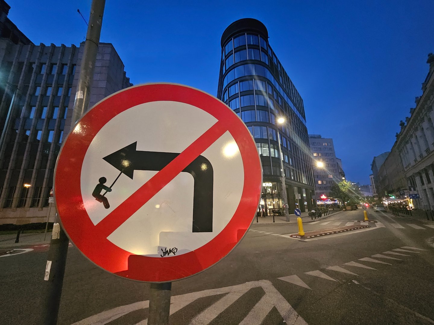 Street art sur panneau de signalisation représentant un garçon sur une balançoire