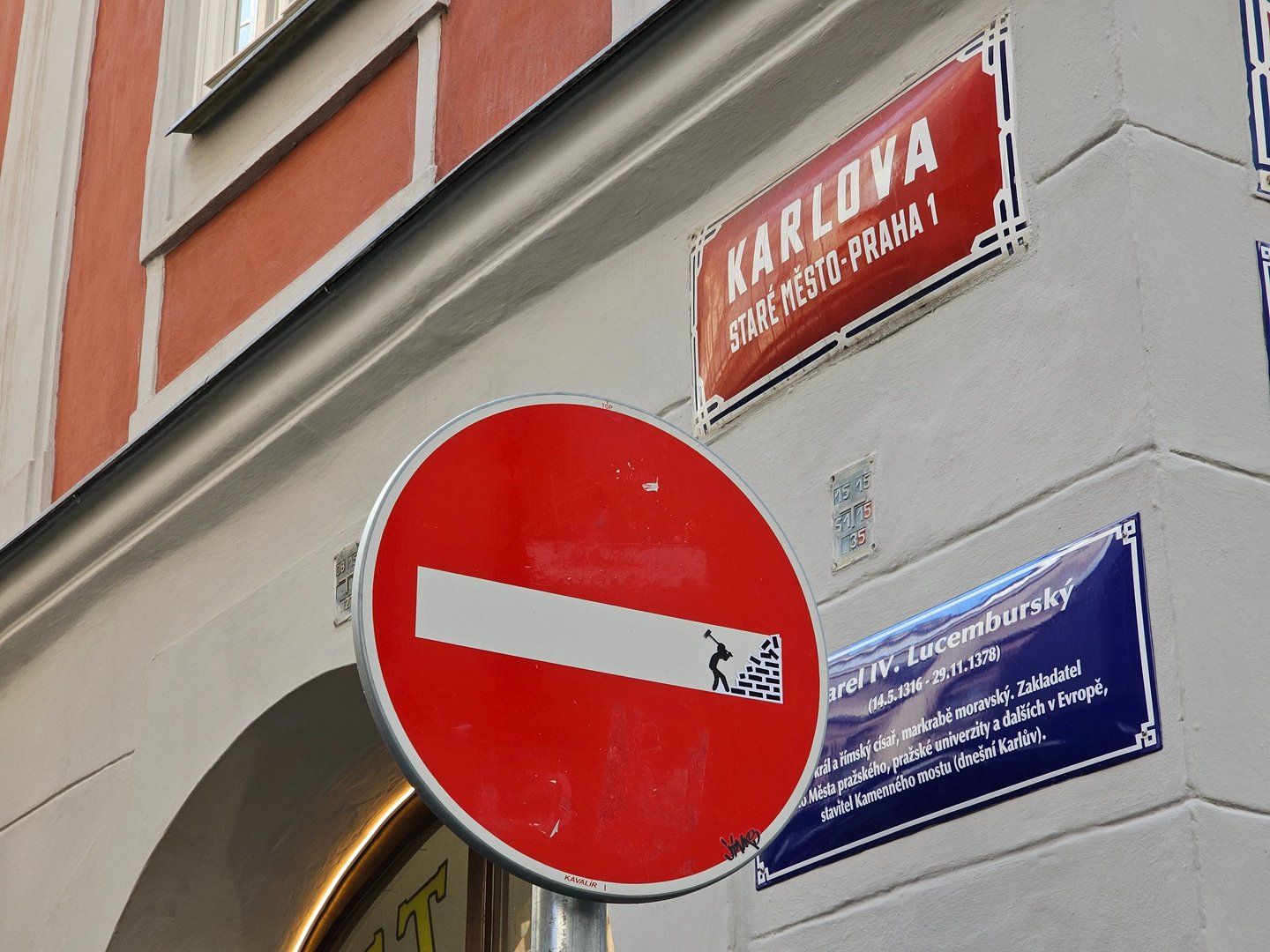 Détournement de panneaux de signalisation représentant un homme détruisant un mur sur sens interdit 