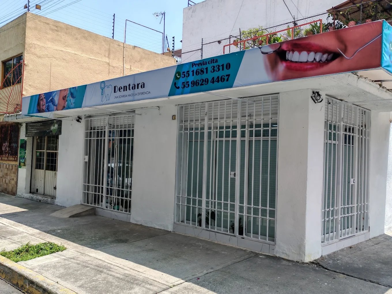 Exterior de la clínica dental Dentara con señalización profesional y rejas de seguridad en una calle