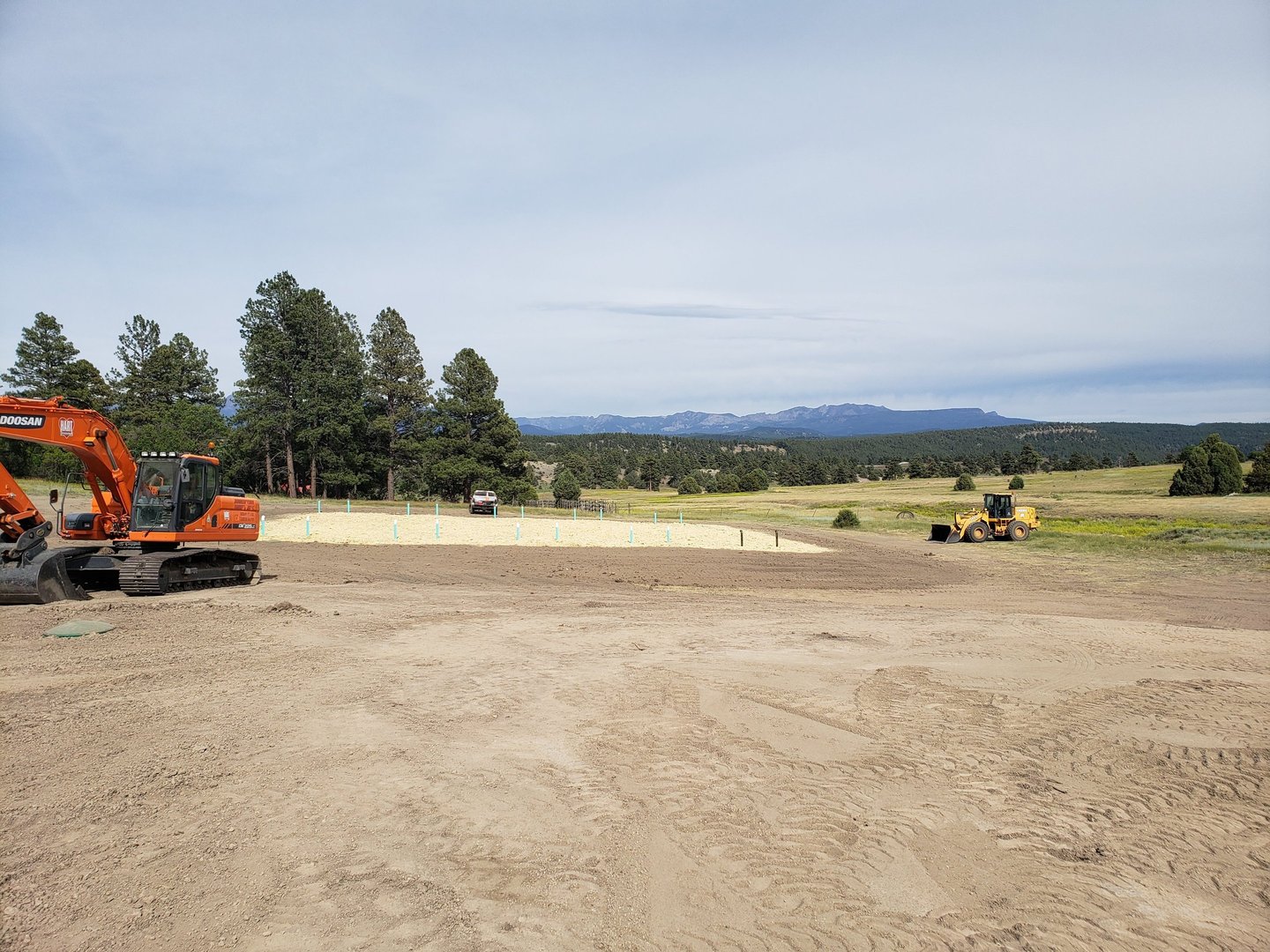 a tractor with a tractor loader in the background
