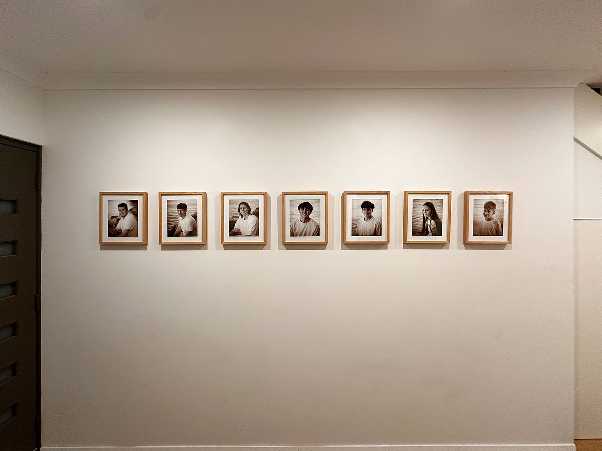 7 framed prints all in a row on the wall