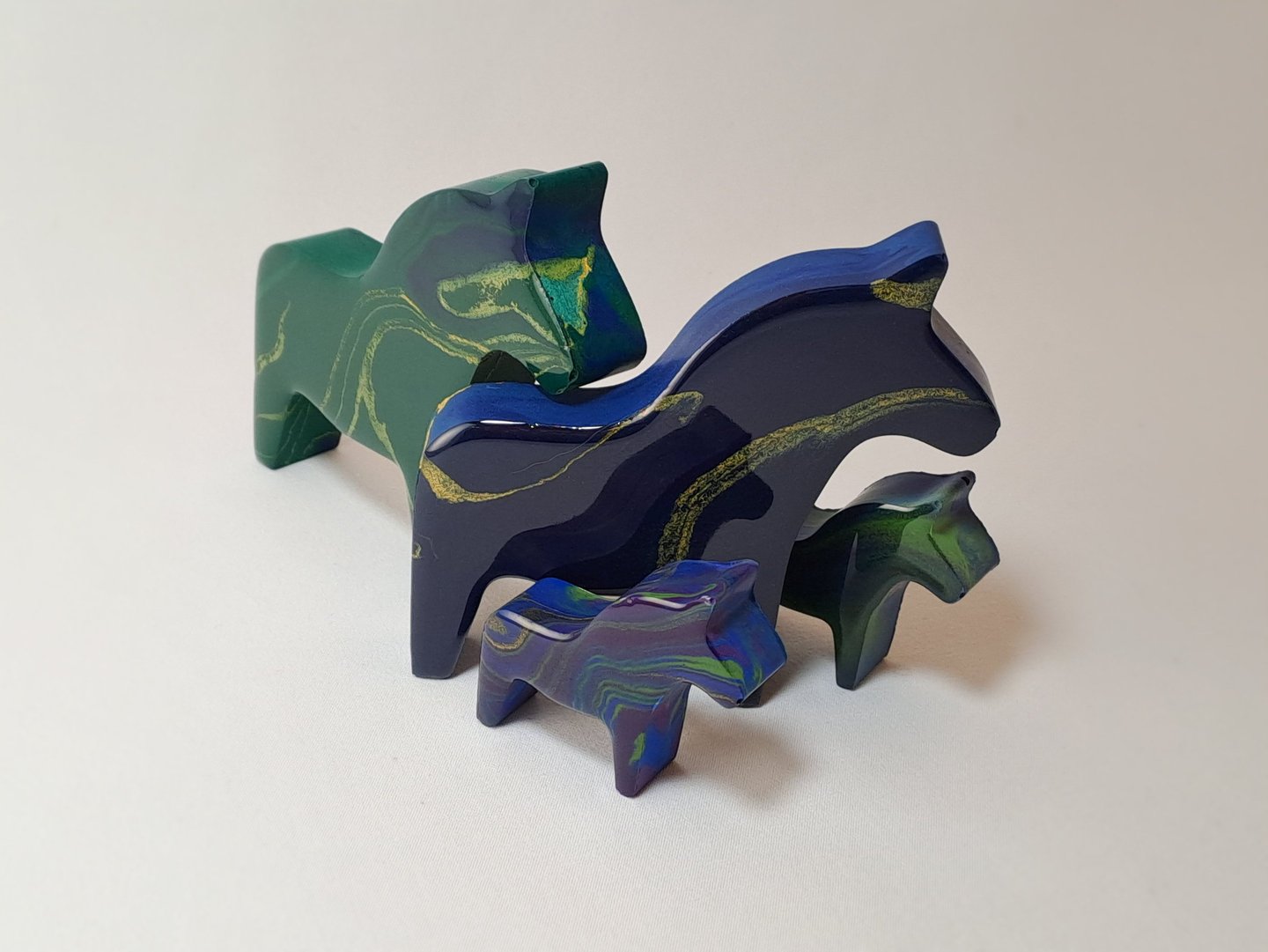 Handcrafted blue and green gypsum and resin horse figurines with northern lights design.