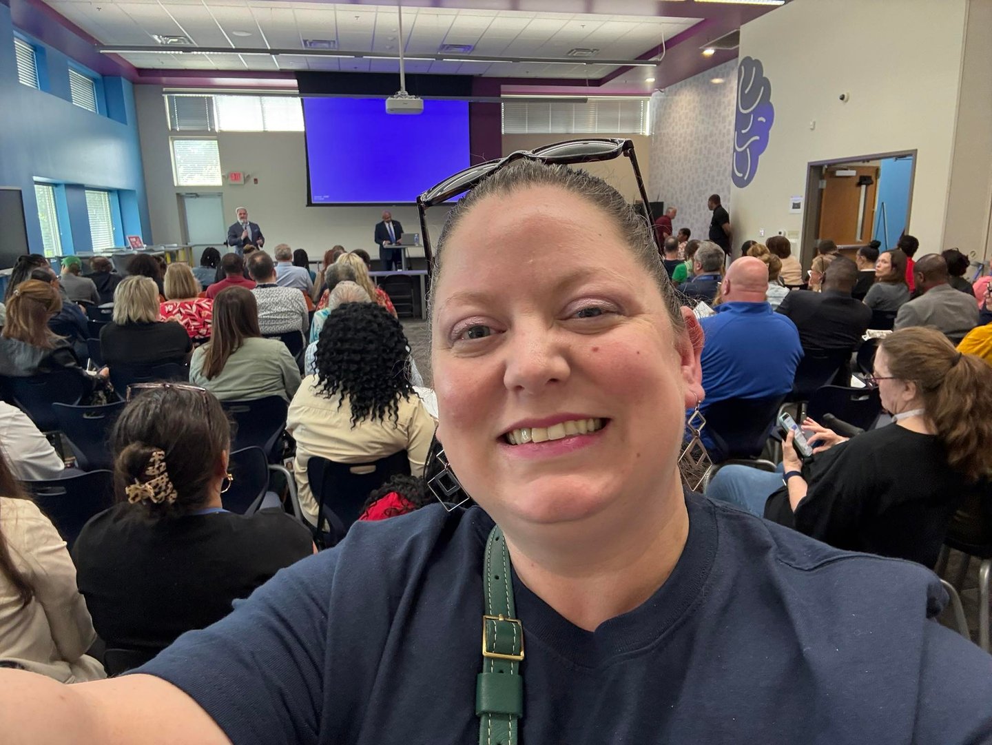 Selfie photo with organization meeting in background
