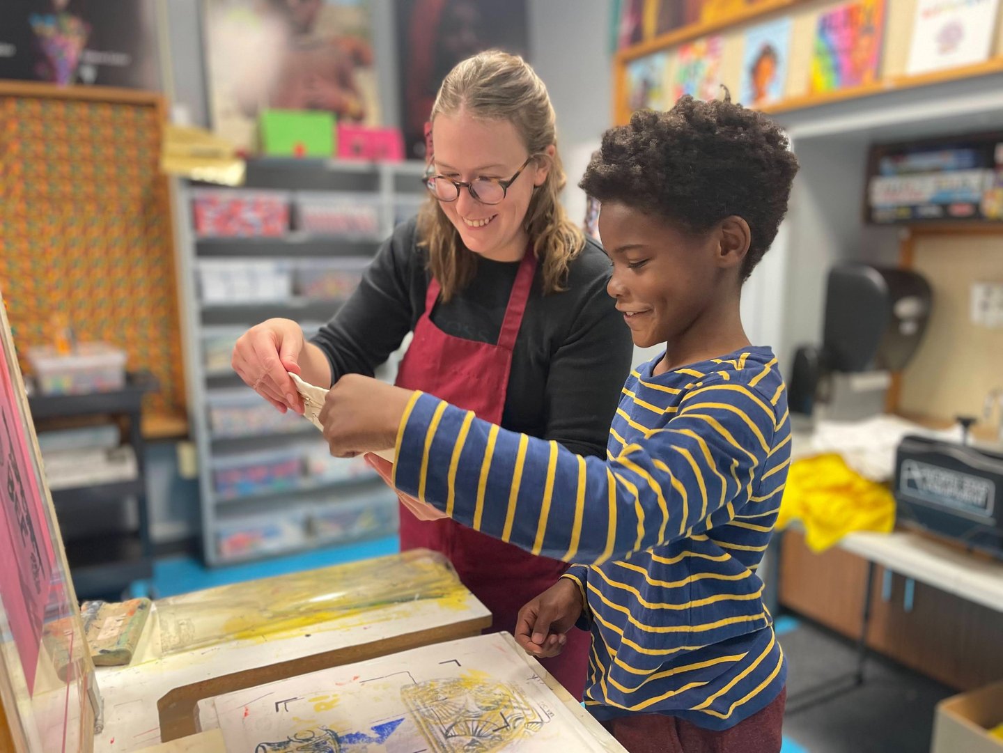 One of our teachers printing with a smiling Benton student.