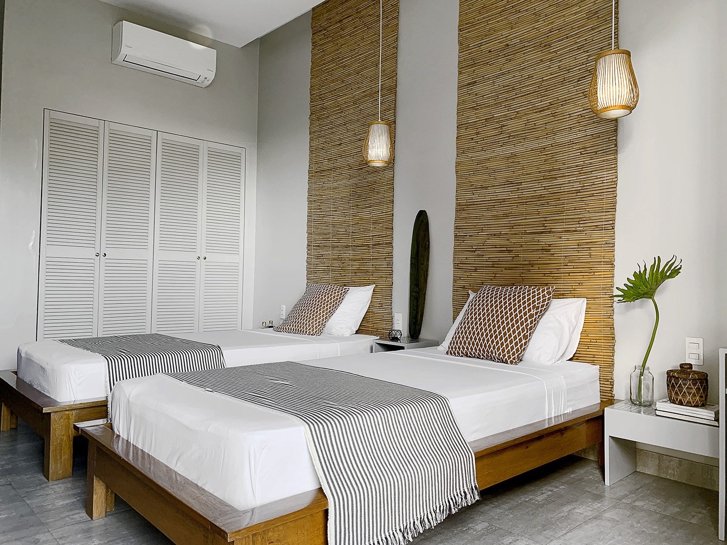 a bedroom with two beds and a surfboard