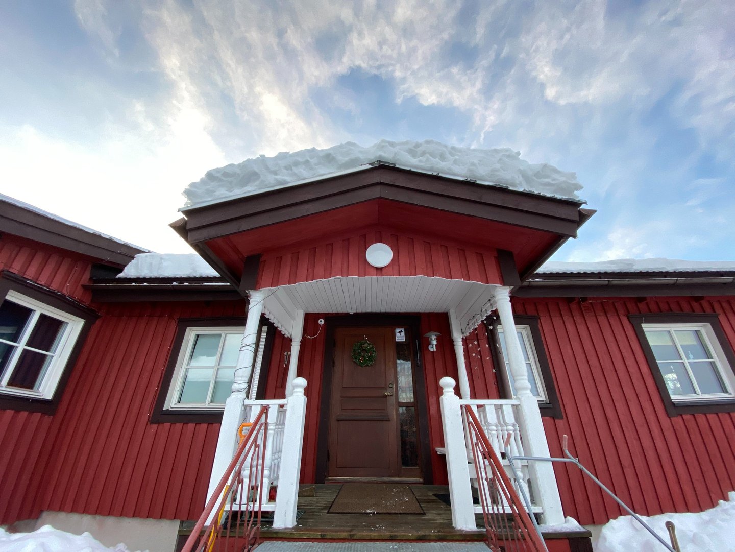 a red house with a red door and white stairs