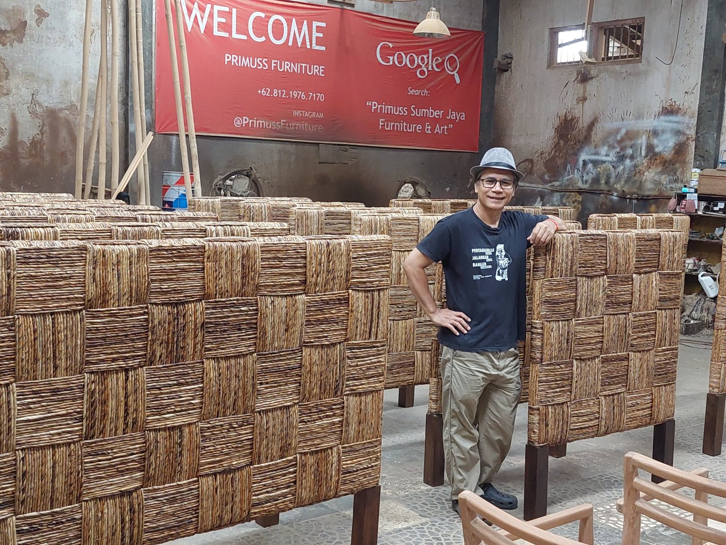 Jiwo standing in front of a large group of headboard weaved by banana fiber