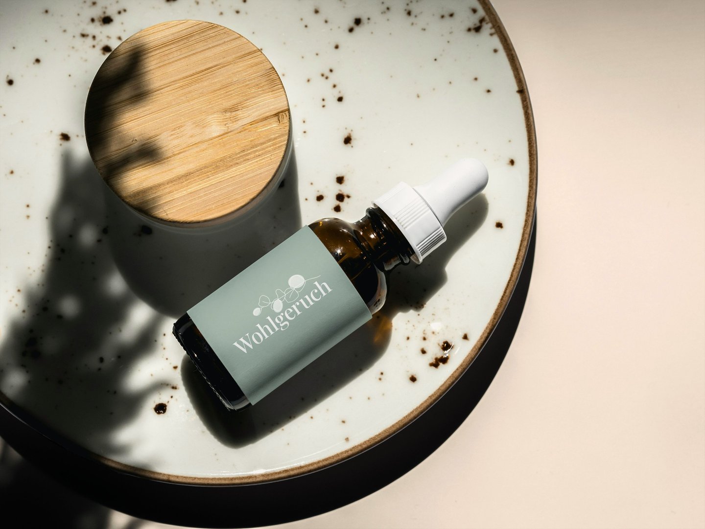 Eine Pipettenflasche aus Braunglasauf einem Keramikteller mit natürlichen Schatten.