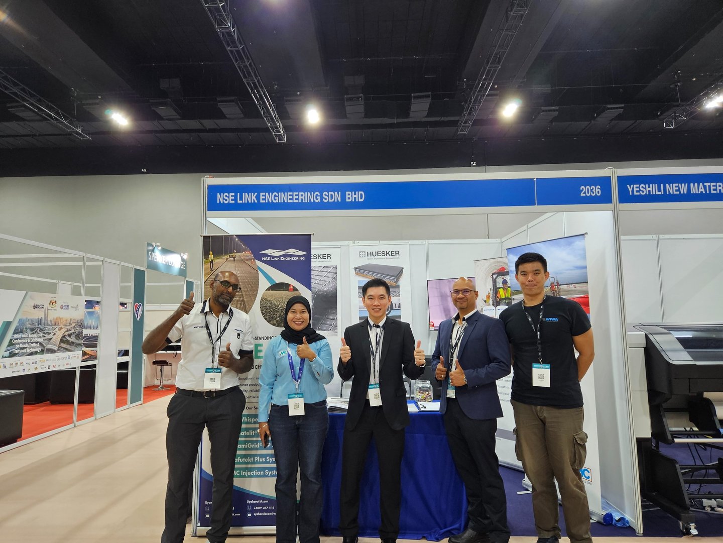 NSE Link Engineering team posing at their professional trade show booth during a construction industry exhibition.