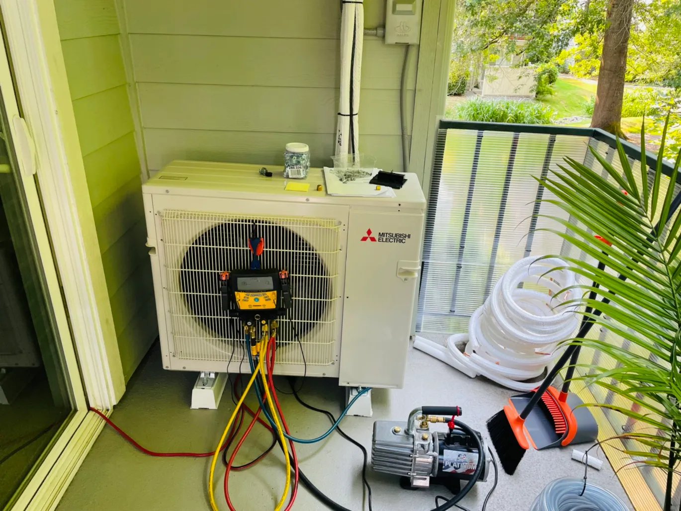 Engineer doing annual maintenance checks and readings on an Ac System on a balcony