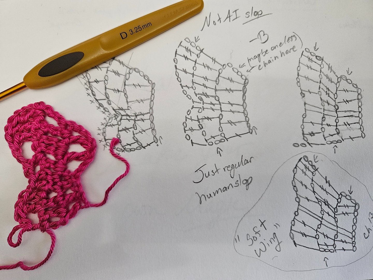 pink crochet item and crochet hook on a paper with crochet charts