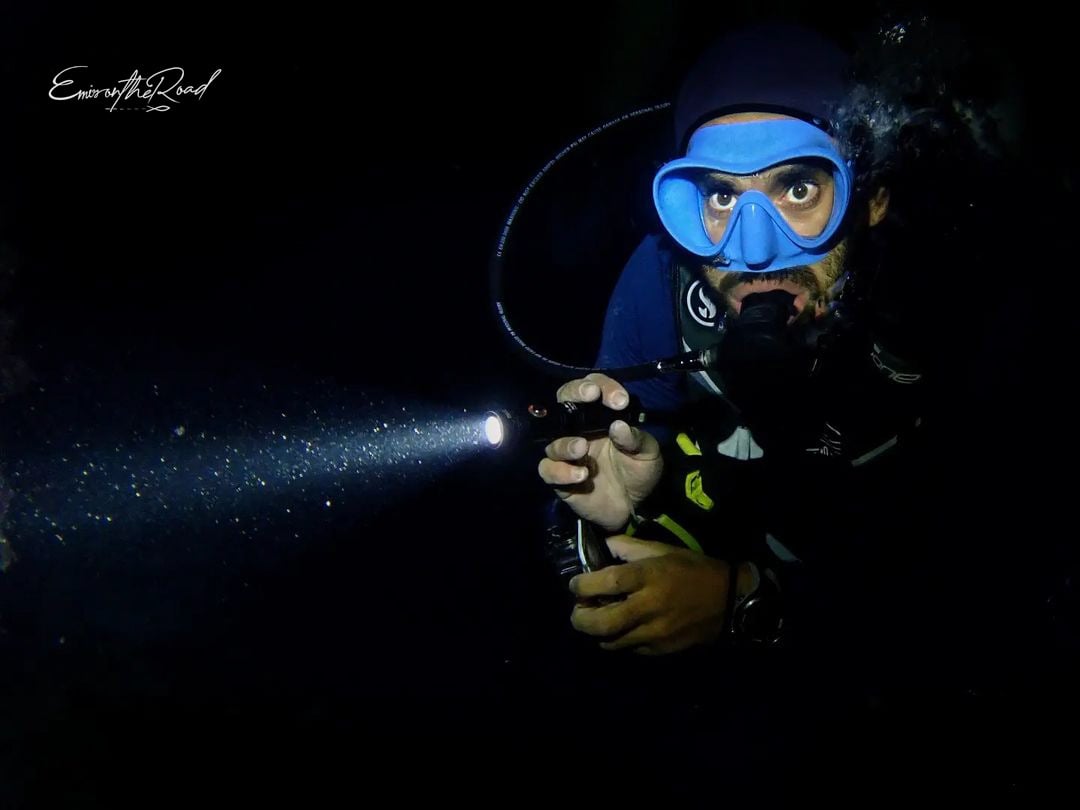Advanced Scuba diver diving with a torch during a night dive at Gili Trawangan