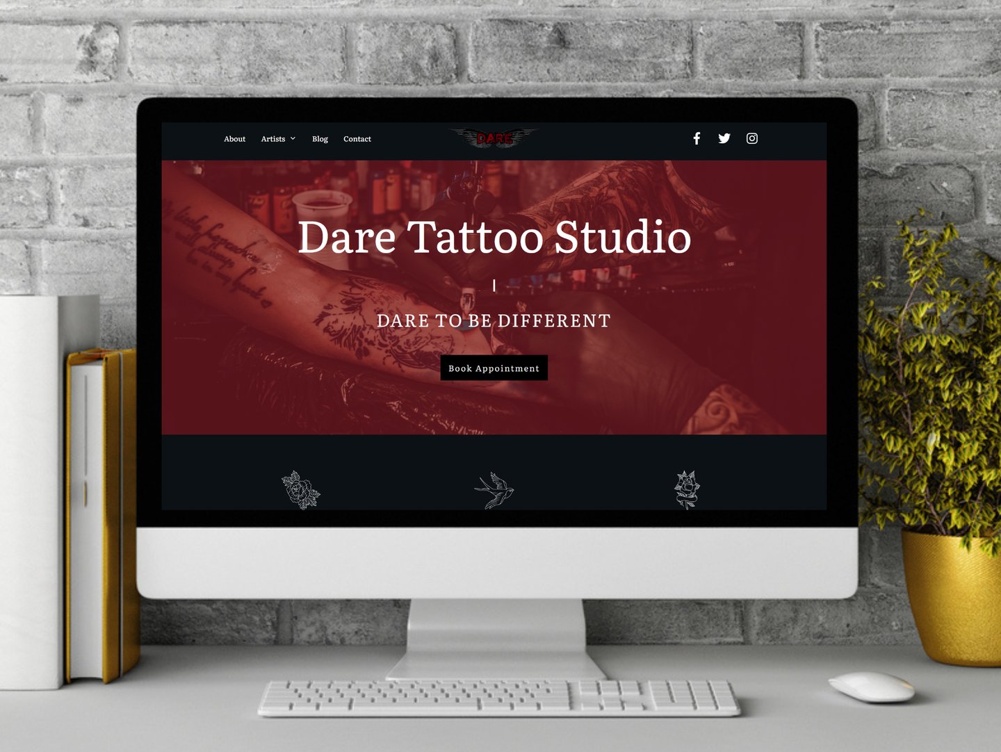 a computer screen on a desk showing the home page of a tattoo studio on the screen