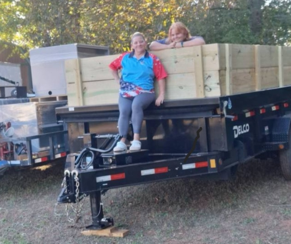 The owner, Sherieanne Skinner, and her daughter, Lily, on the Guaranteed Junk Removal dump trailer.