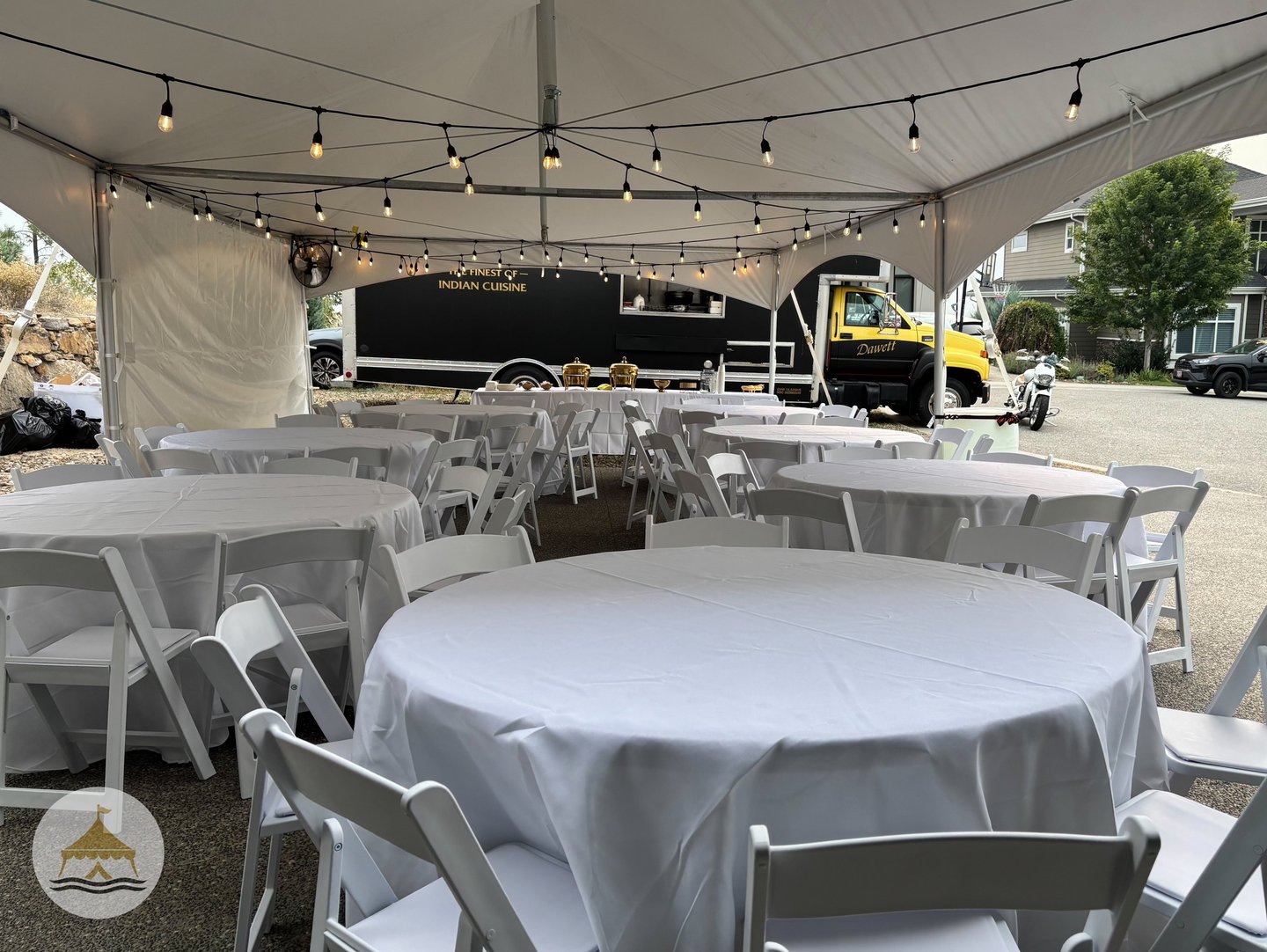 a table with white tables and chairs and a truck parked in front of a truck