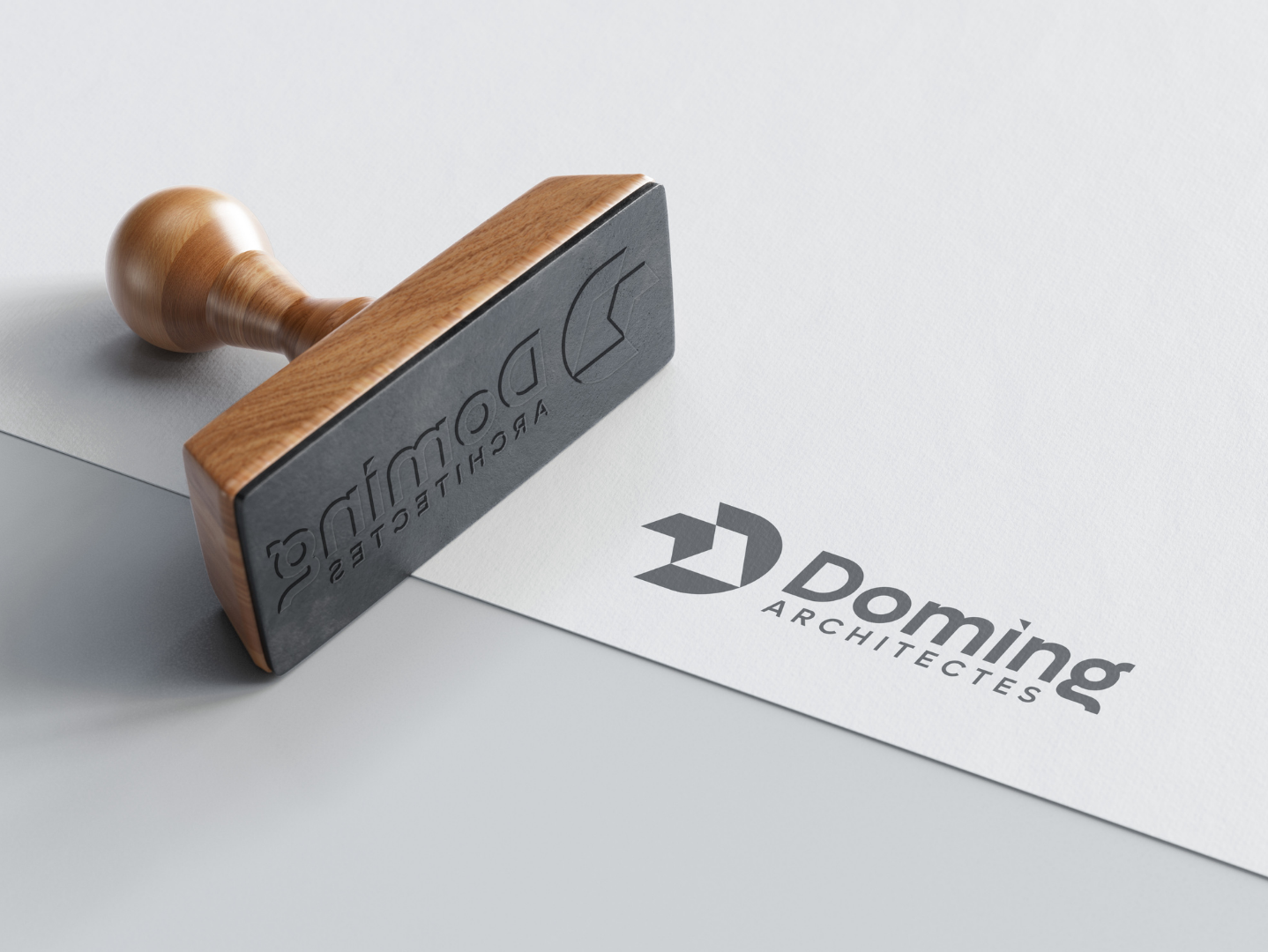 A wooden rubber stamp next to the architects logo printed on white paper.