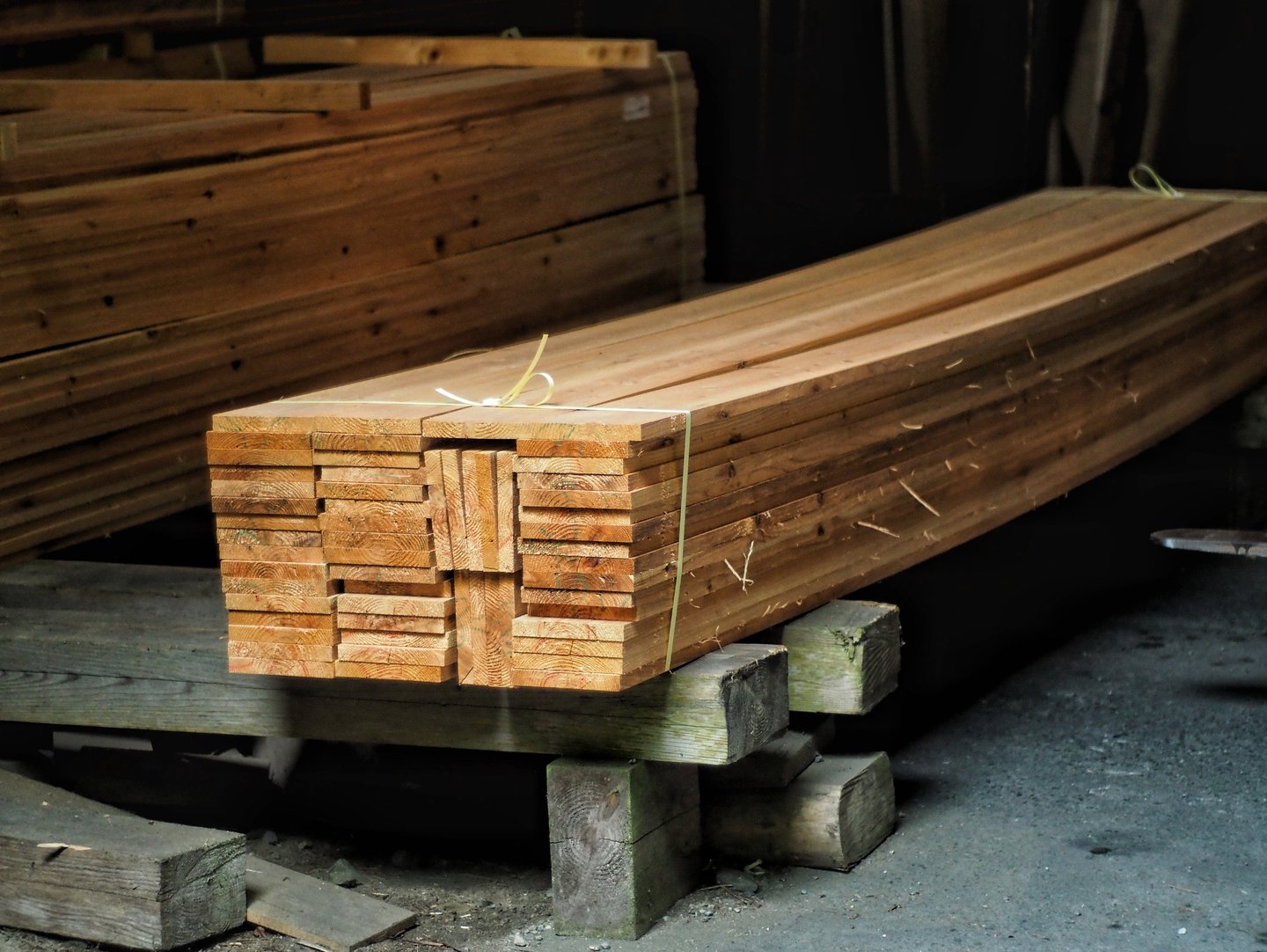 Stack of high-quality sugi cedar lumber planks tied for construction in a sawmill.