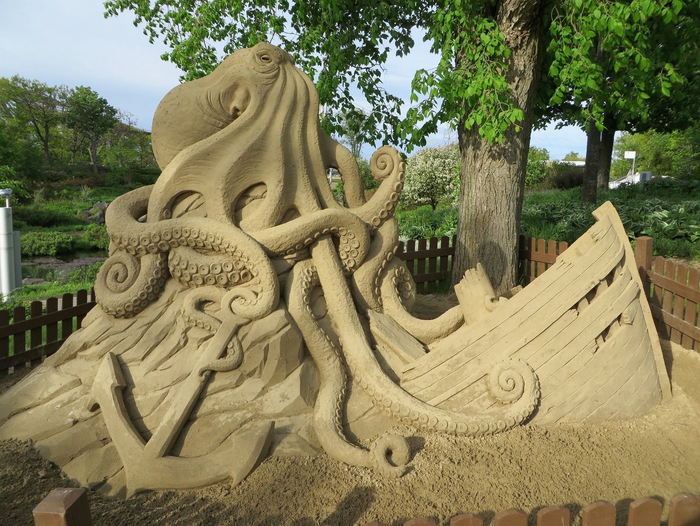 sand sculpture of a kraken with a sunken ship