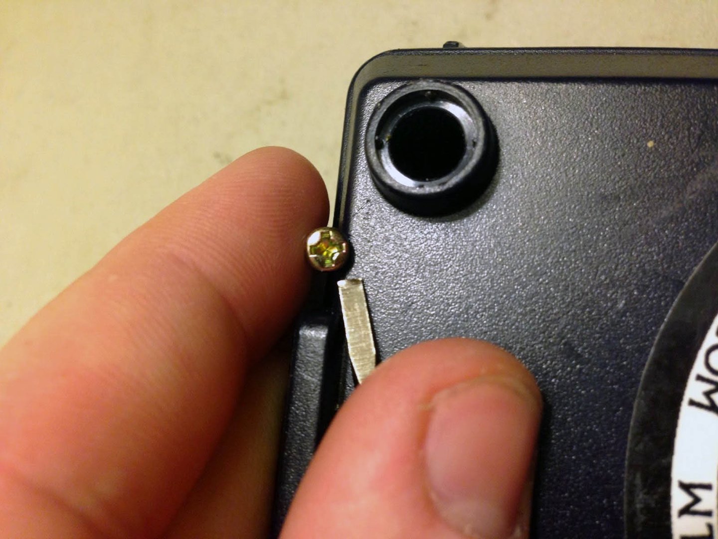 a person holding a small piece of metal with a small screwr