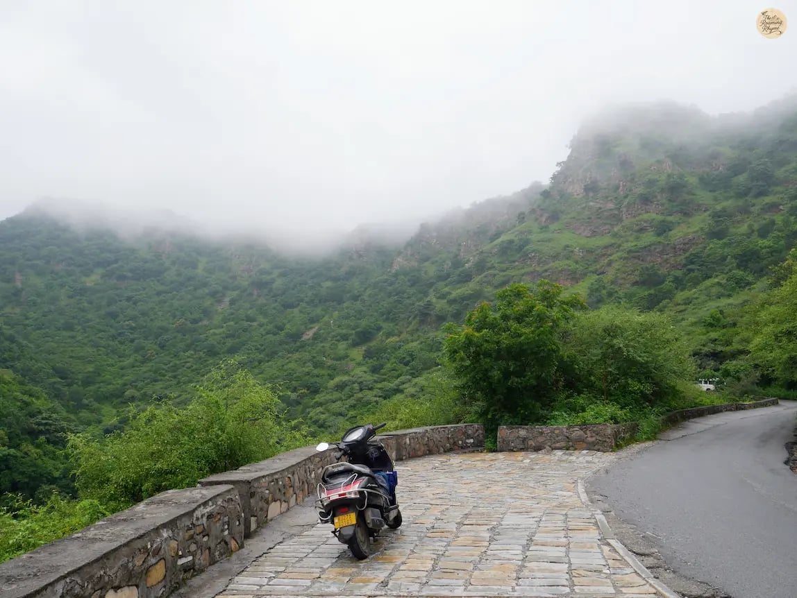 Curved forest trail on the hills leading up to Sajjangarh Fort udaipur under cloudy skies.