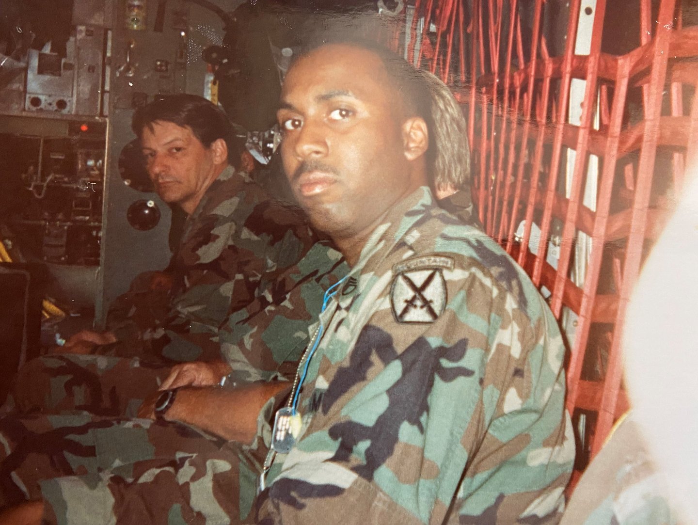 Lee A Jones in camouflage gear sitting in a military transport helicopter