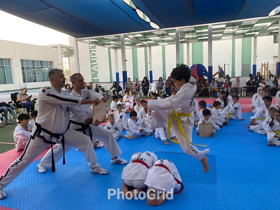 Junior taekwondo student performing flying board break, Dubai