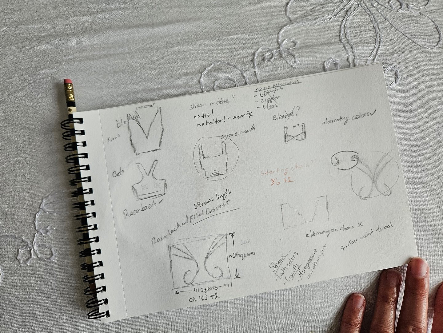 Hand-drawn pencil sketches and crochet pattern notes for a DIY top in a spiral notebook.