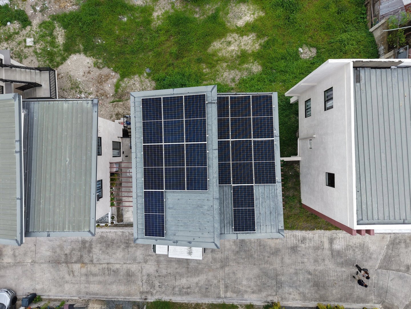 Aerial view of residential solar panel installation on a flat rooftop for renewable energy.