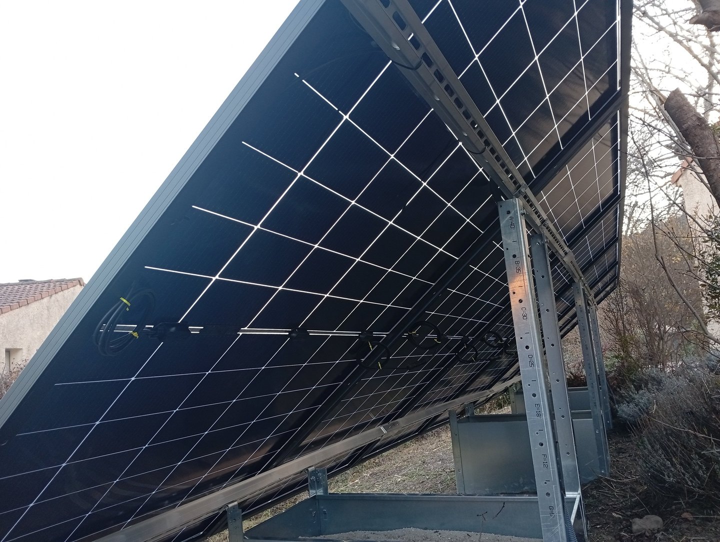 Vue arrière panneaux bifaciaux installés au sol sur structure lestée