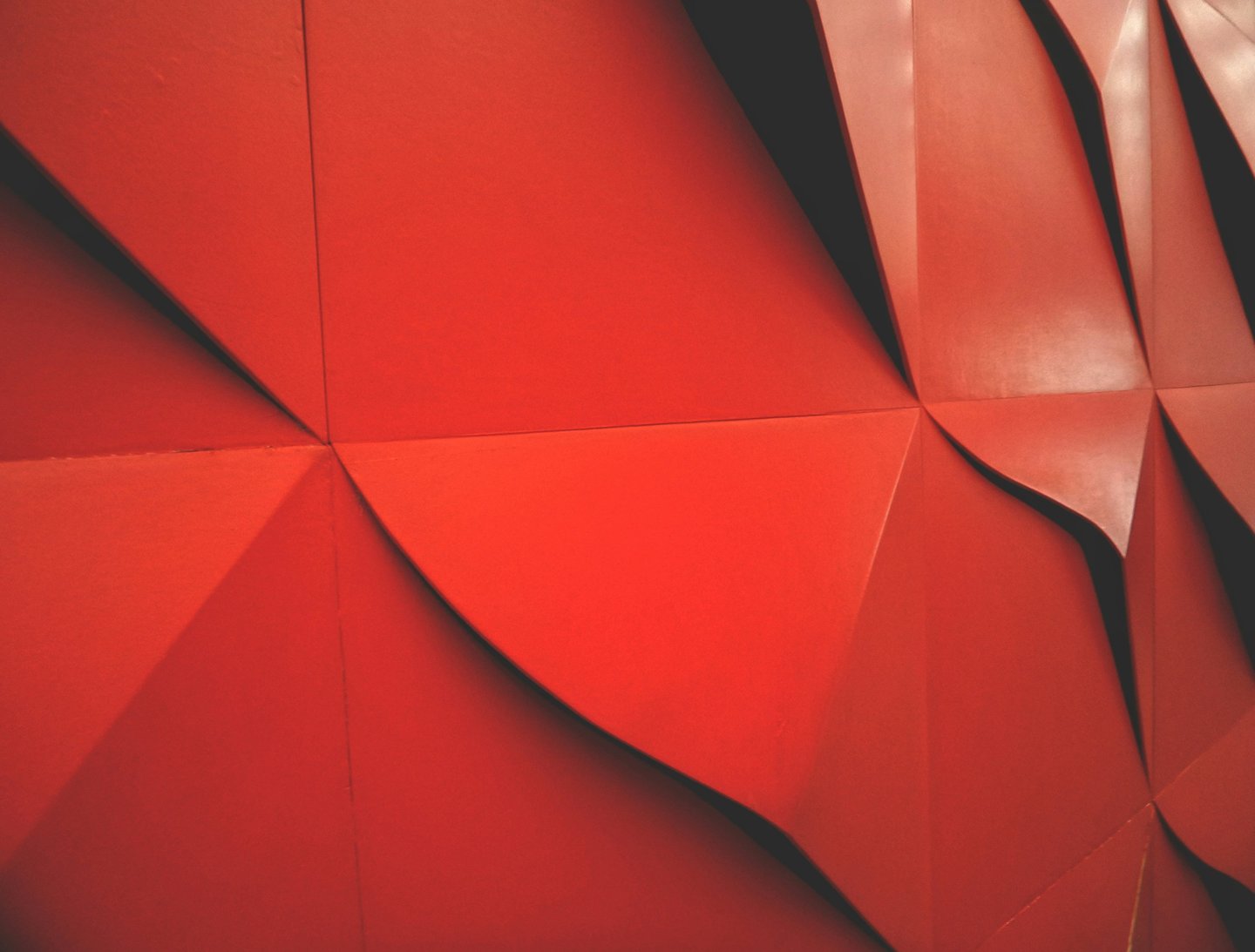 a red wall with large wavered wallpapered structure