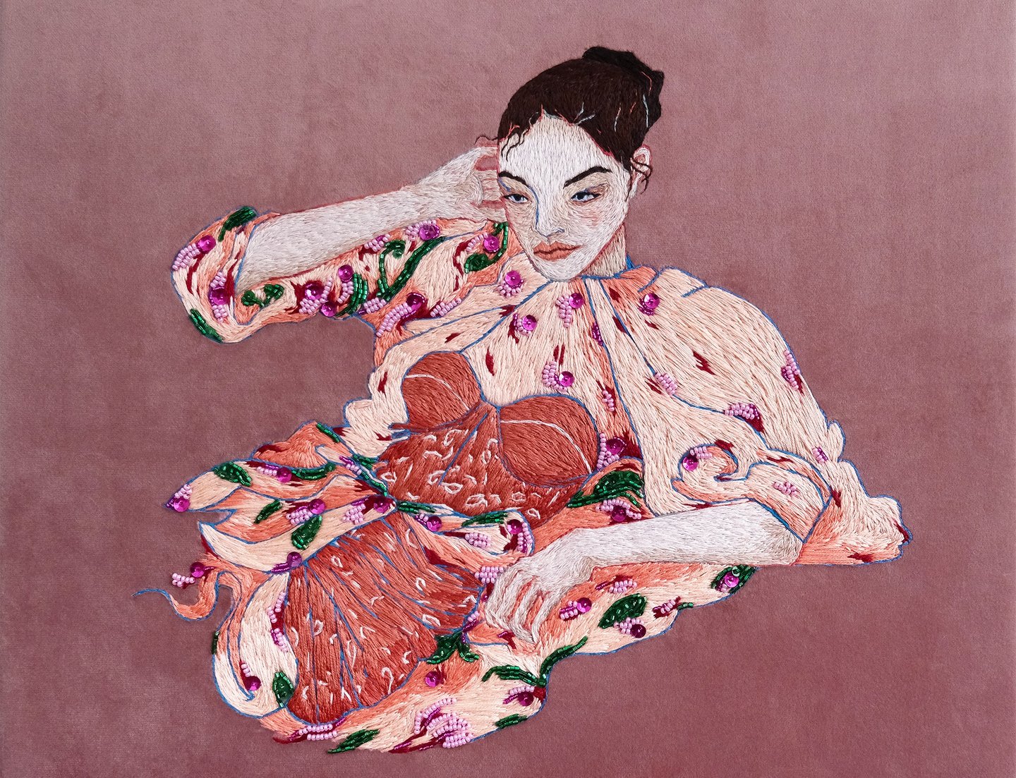 Embroidery of a woman in a pink dress with flower sitting on a chair