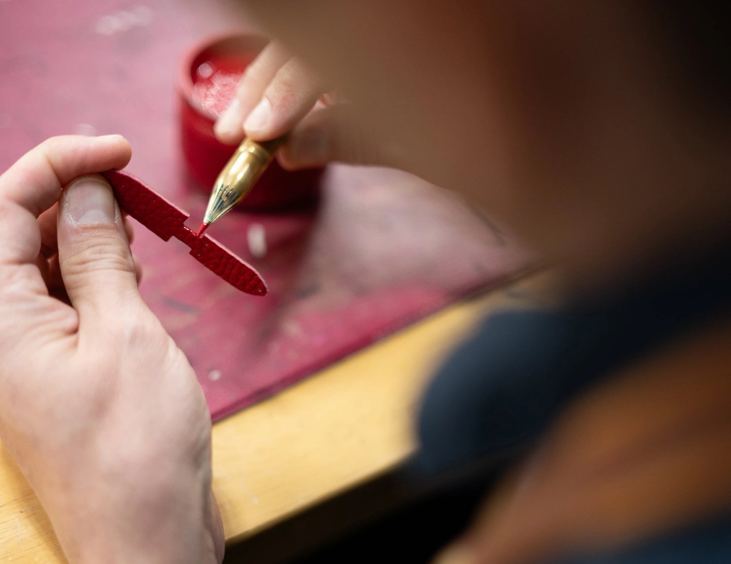 Application à la main de teinture sur la tranche d'une tirette en cuir