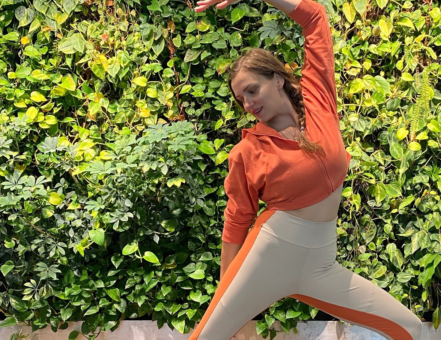 a woman in a red shirt and white pants doing yoga