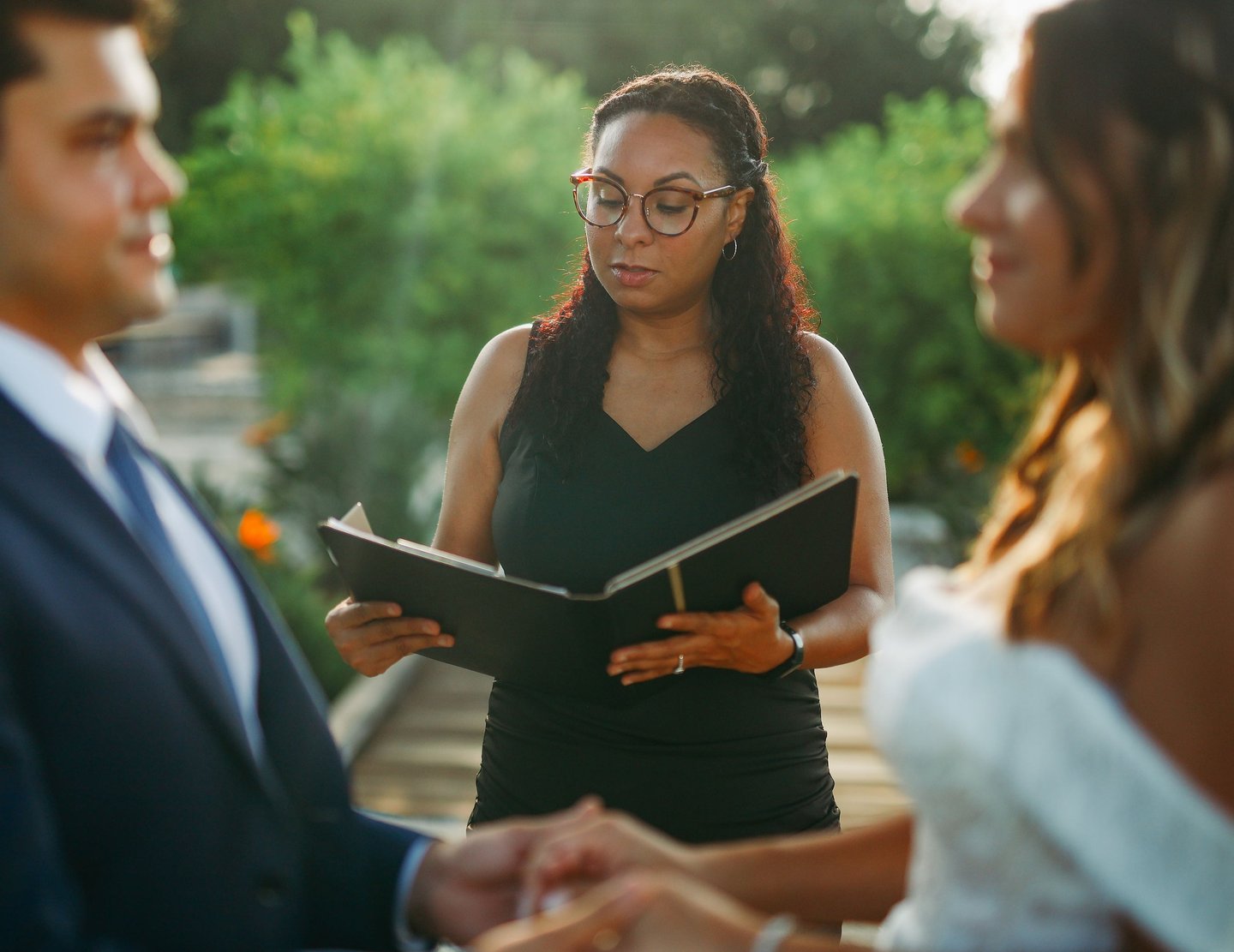 Professiona Florida wedding officiant reading vows for a couple during an outdoor marriage ceremony.