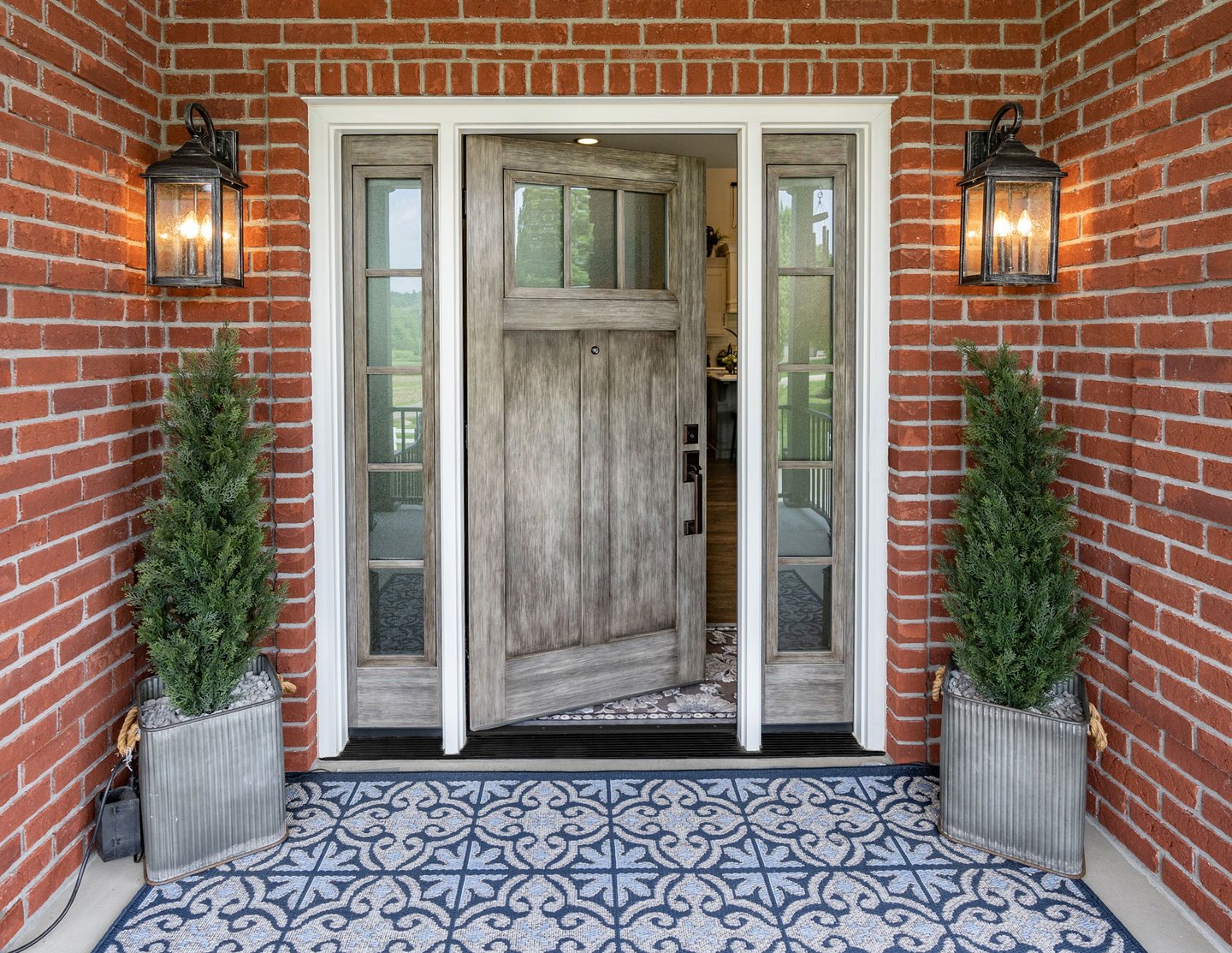 a front door with a brick wall and a potted planter