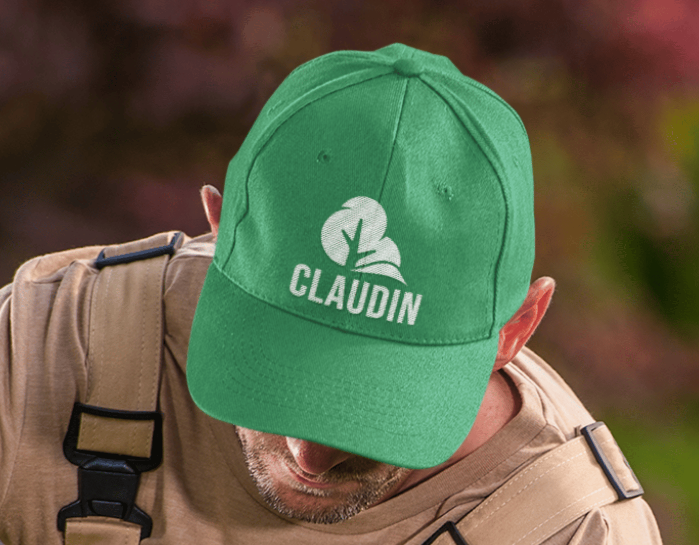 Un homme portant une casquette verte avec un logo d'entreprise de paysagistes.