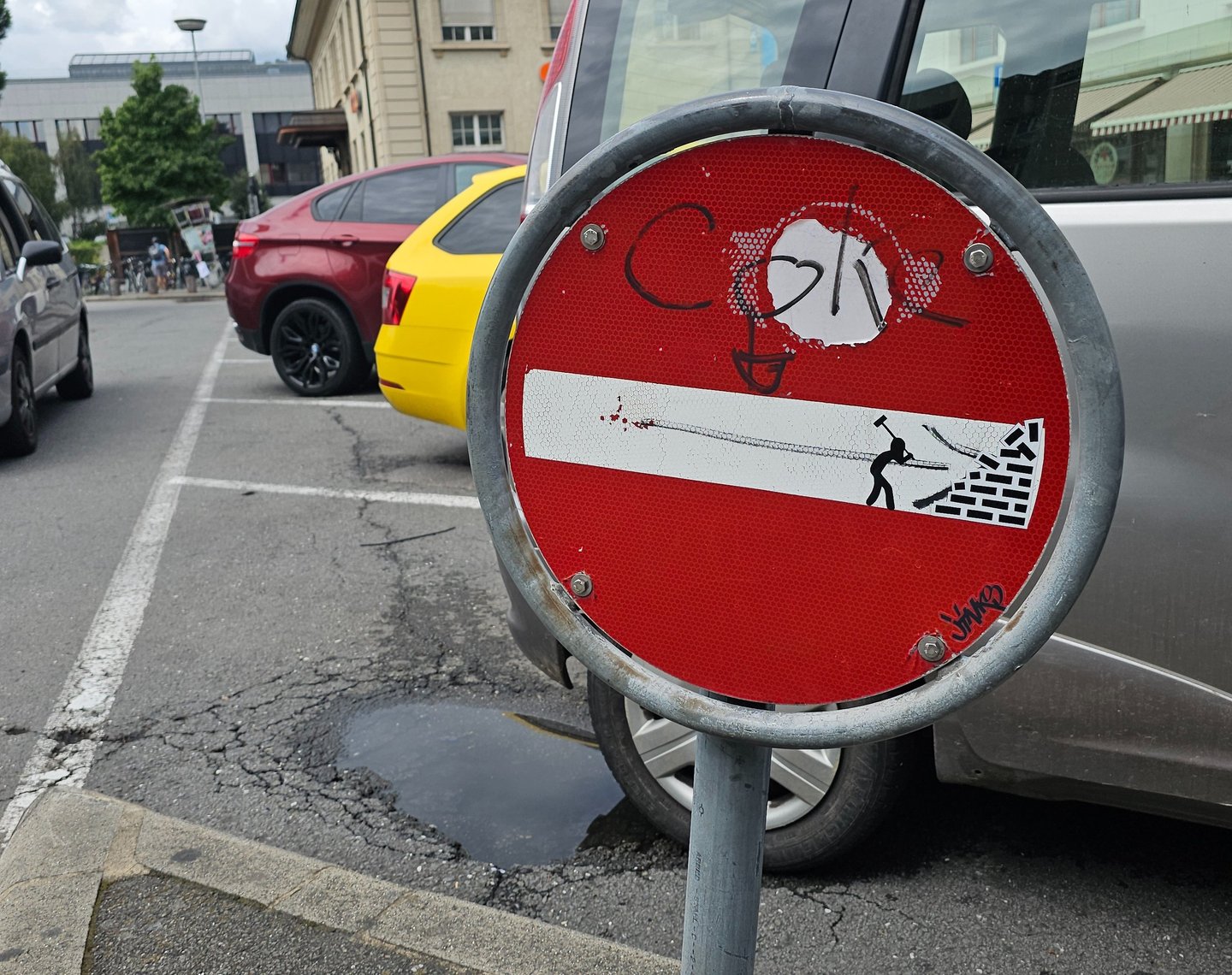 Détournement de panneaux de signalisation représentant un homme détruisant un mur sur sens interdit 