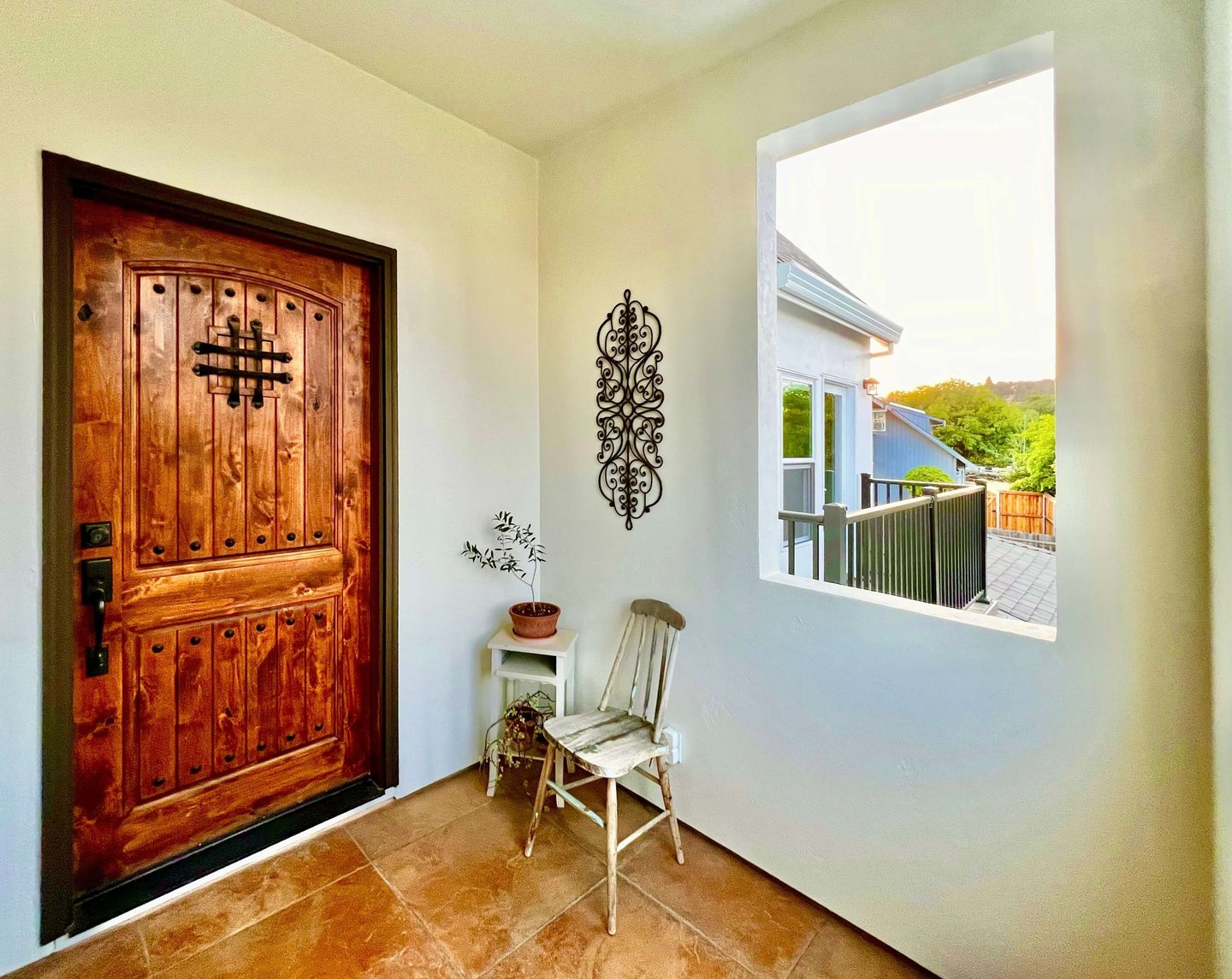 Welcoming entryway with a warm stained wood door and seating area.