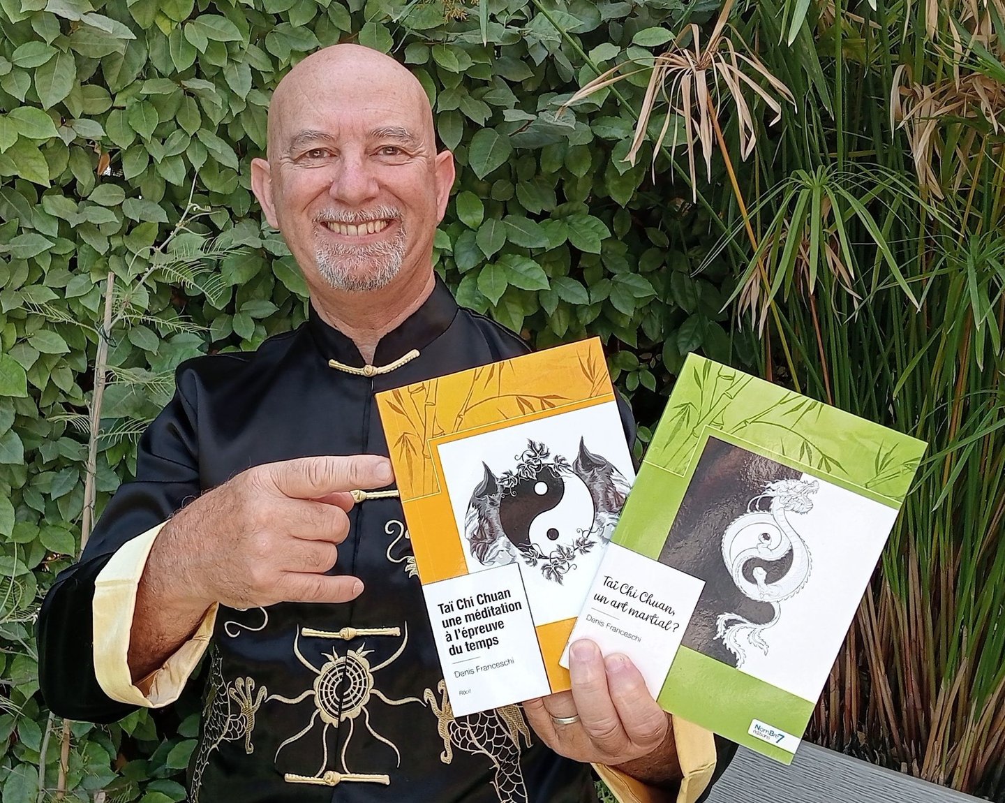 a man in a black shirt holding up a book